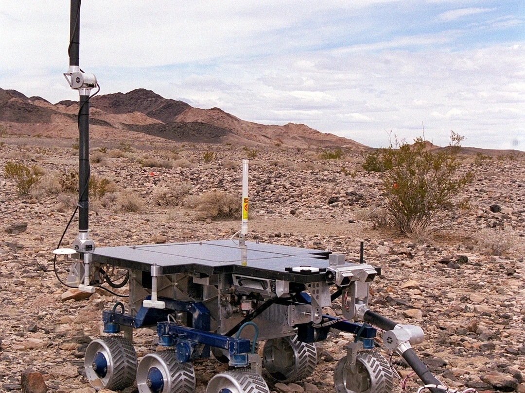 NASA FIDO rover with its panoramic camera mast and robotic arm deployed at a test site