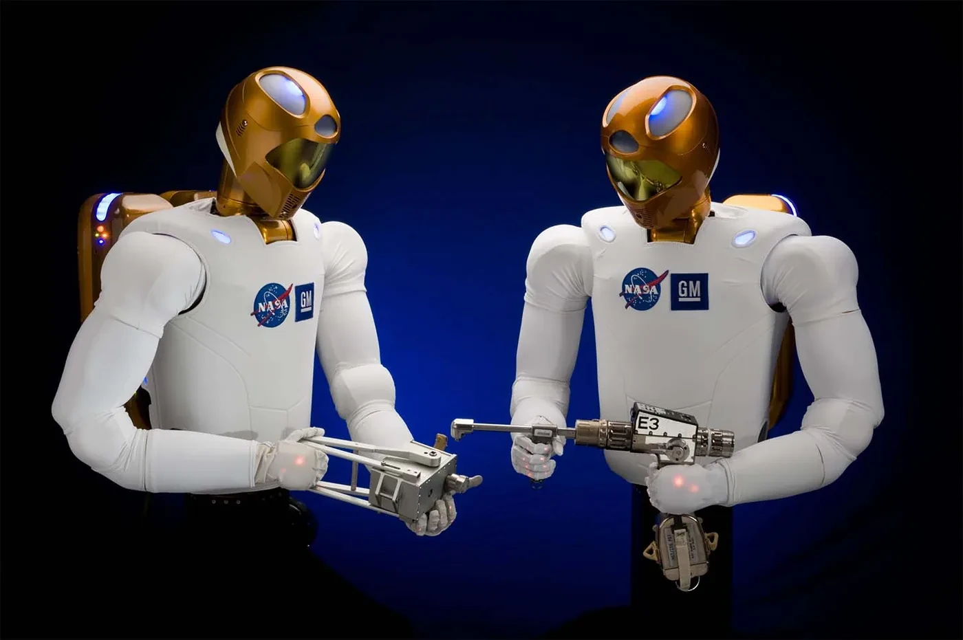 Two NASA Robonaut 2 upper-body humanoid robots holding tools
