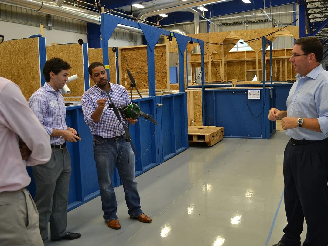 Researcher explaining equipment inside a NIST robotic test facility