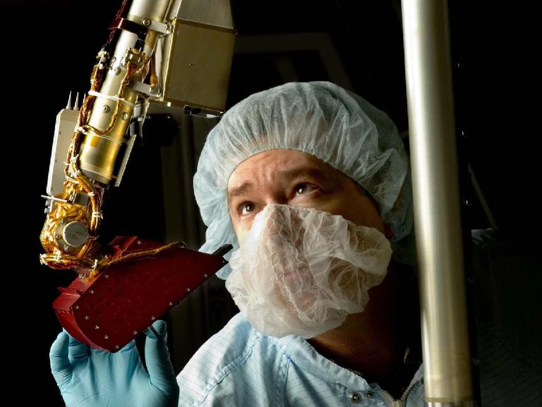클린룸에서 기술자가 NASA Phoenix 착륙선 로봇 팔을 점검하는 모습