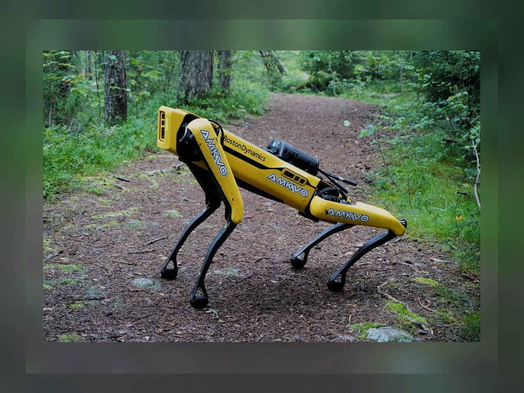森の小道に立つ黄色いBoston Dynamics Spot四足歩行ロボット