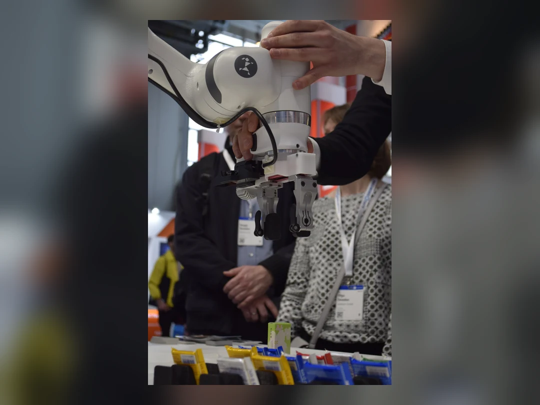 A person manually guides a Franka robot arm