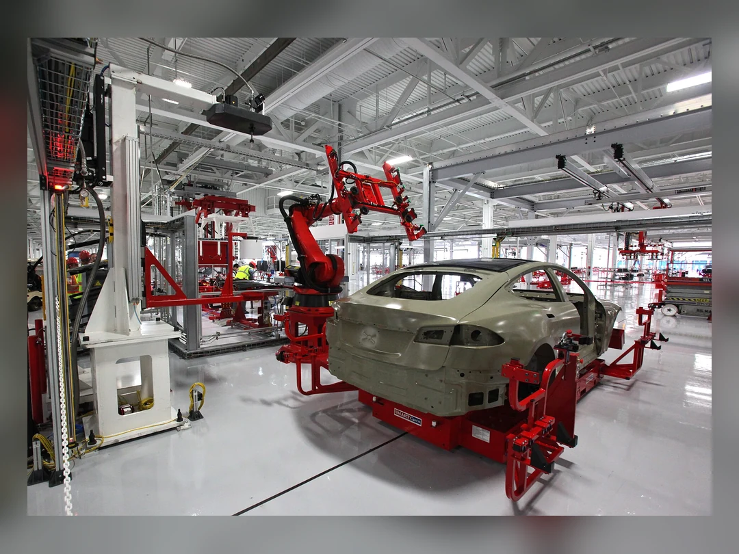自動車ボディの周囲で作業する複数の産業用ロボットアーム