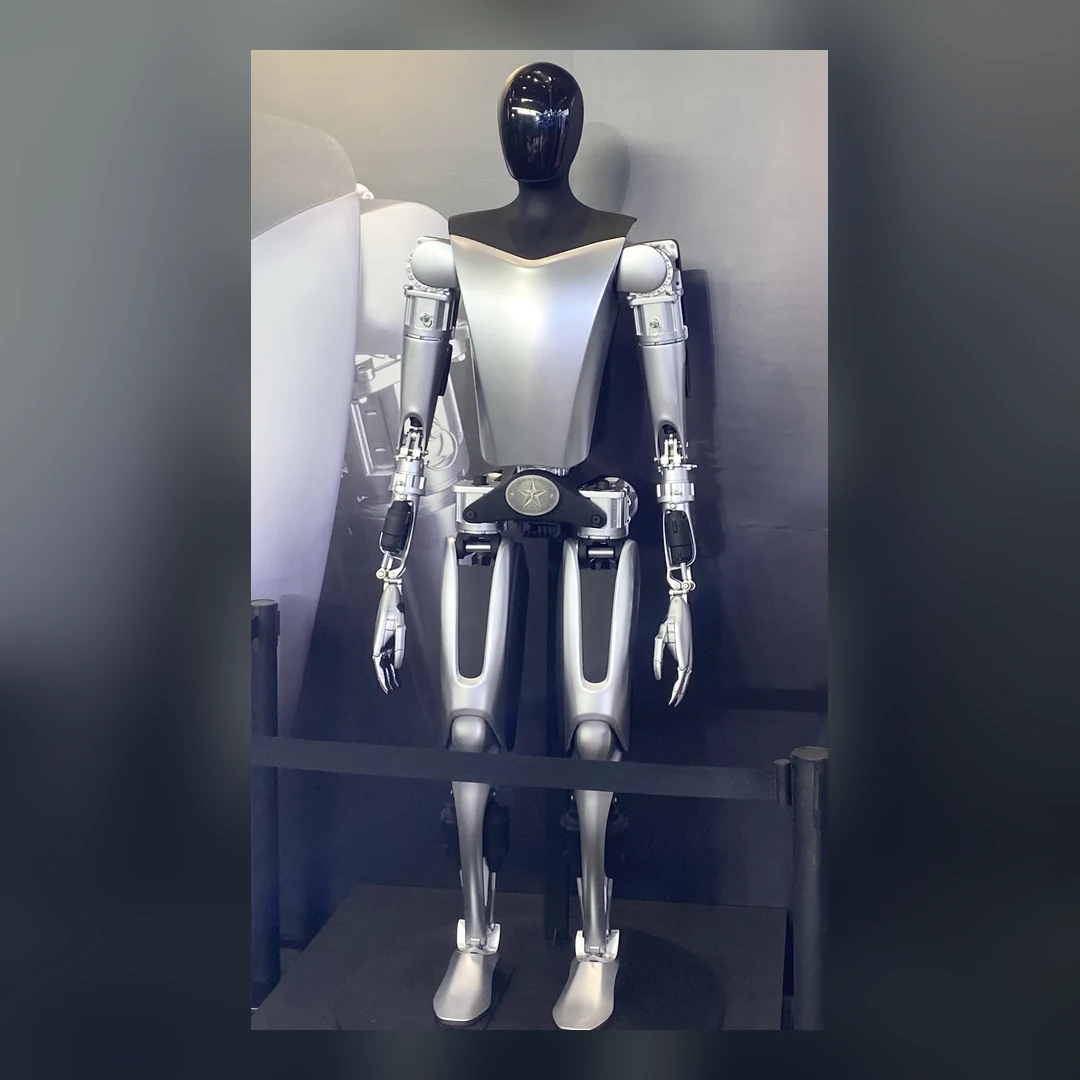 Real photograph of a Tesla Optimus humanoid robot at a 2023 exhibition