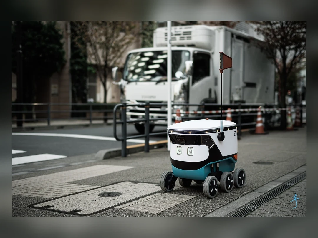 行駛在東京城市人行道上的 Cartken 配送機器人
